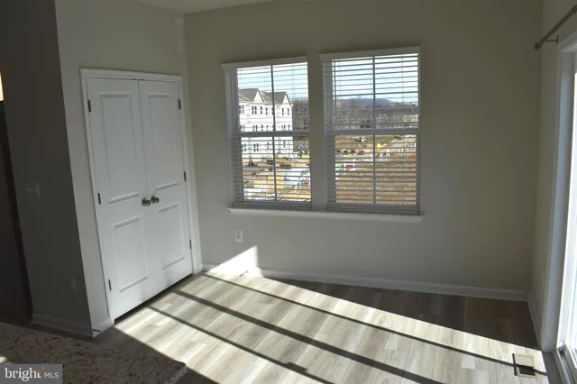 a view of a bedroom with wooden floor and windows
