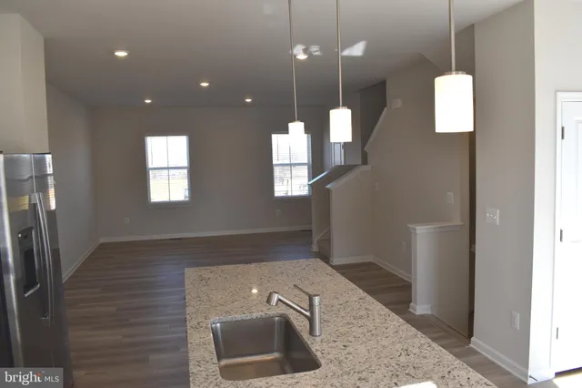 a view of a hallway with wooden floor and a bathroom