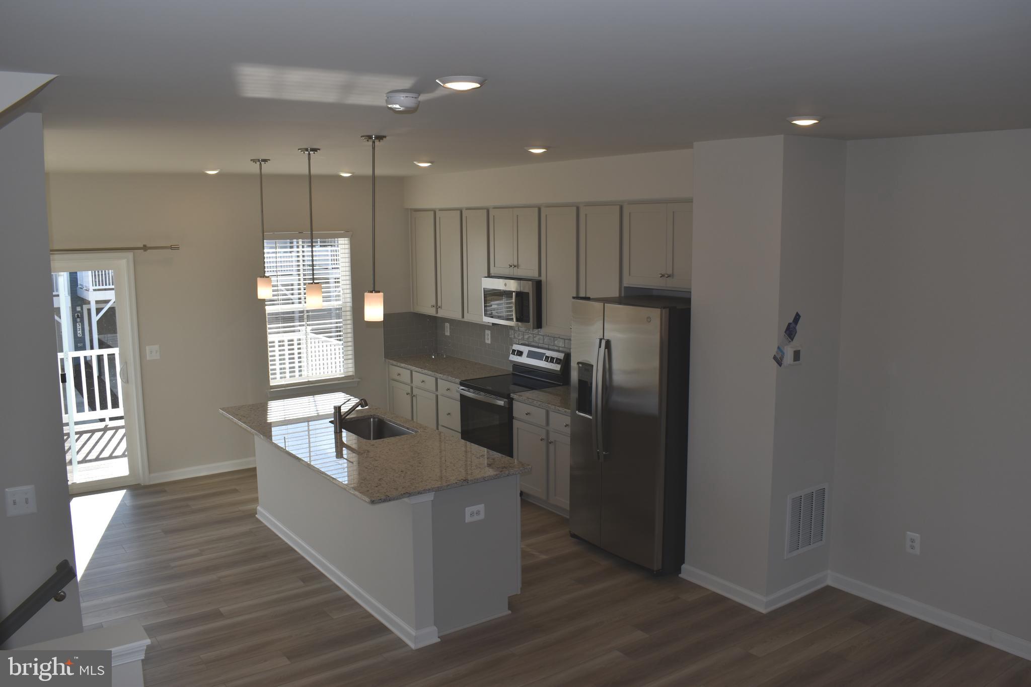 224 Swan Fld Avenue Ranson, WV 25438 - Photo 32 of 34 a kitchen with kitchen island a counter top space a sink stainless steel appliances and cabinets