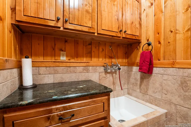 a kitchen with stainless steel appliances granite countertop a sink and a refrigerator