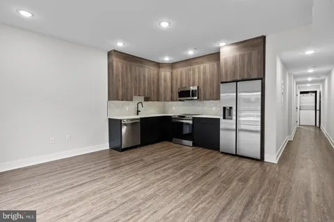 a kitchen with stainless steel appliances granite countertop a stove a sink and a refrigerator