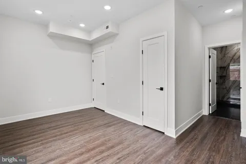 a view of an empty room with wooden floor