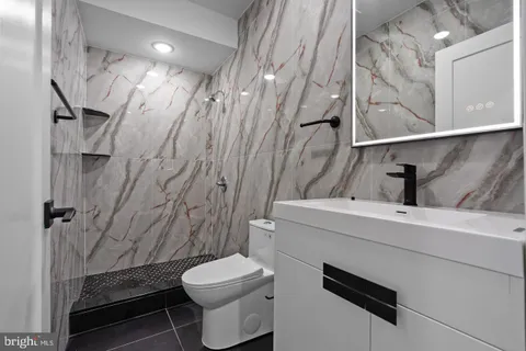 a bathroom with a sink a toilet and shower