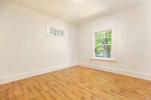 an empty room with wooden floor and closet