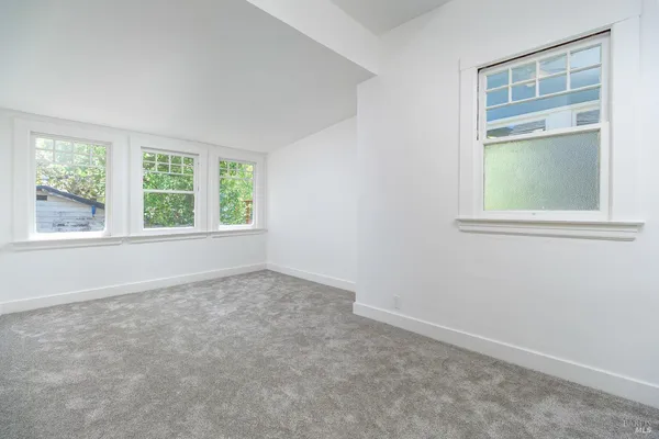 an empty room with wooden floor and a window