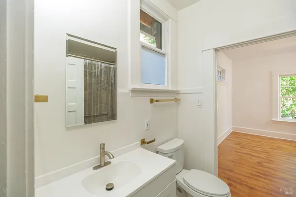 a bathroom with a sink a toilet and shower