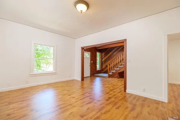 a view of empty room with wooden floor and fireplace