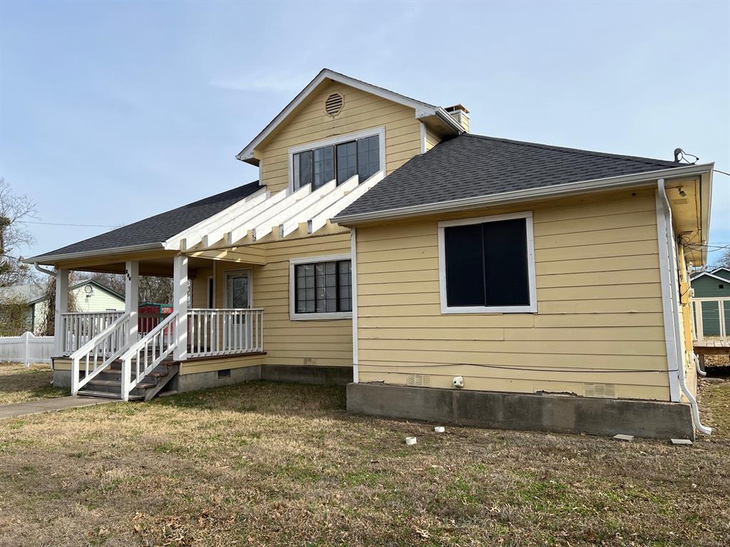 200 Chappell Street Terrell, TX 75160 - Photo 1 of 20 Back of property featuring a shingled roof, a lawn, crawl space, covered porch, and a chimney