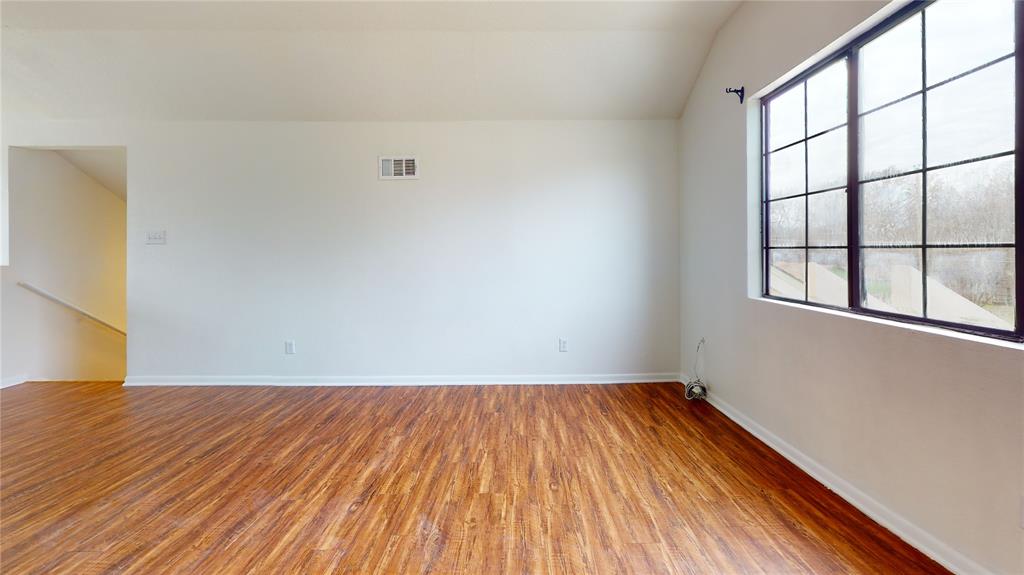 200 Chappell Street Terrell, TX 75160 - Photo 13 of 20 Empty room with wood finished floors and lofted ceiling