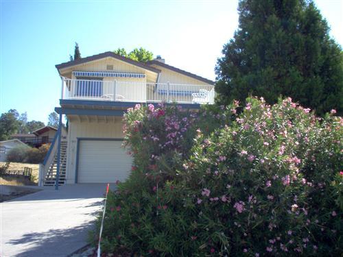 703 Poker Flat Road Copperopolis, CA 95228 - Photo 2 of 24 a front view of a house with a yard and garage