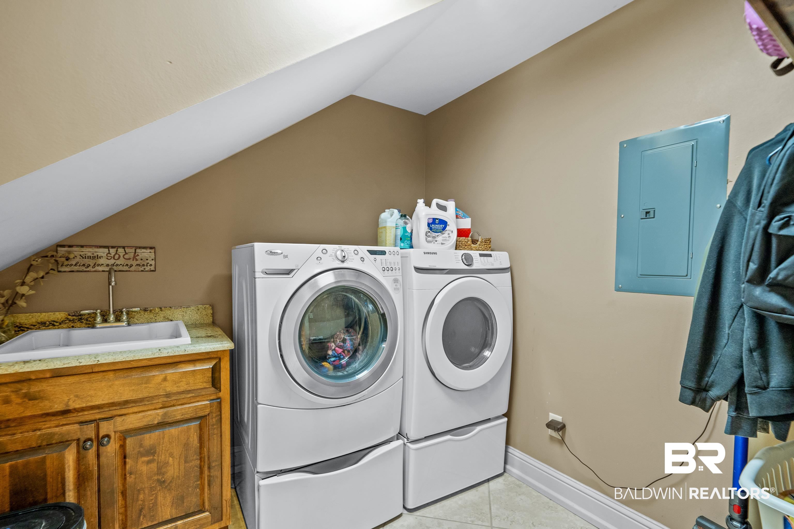 31829 Butler Drive Daphne, AL 36527 - Photo 21 of 48 Washroom featuring electric panel, light tile patterned floors, sink, washer and clothes dryer, and cabinets