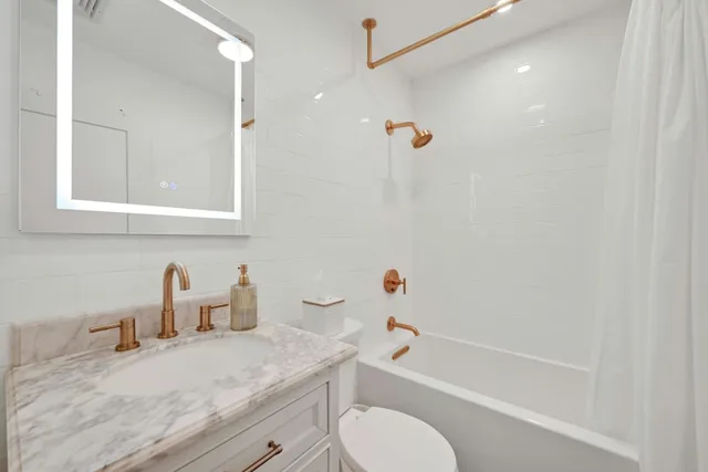 a bathroom with a granite countertop sink toilet and shower