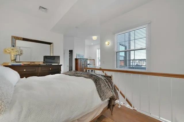 a bed room with a bed window and a dresser