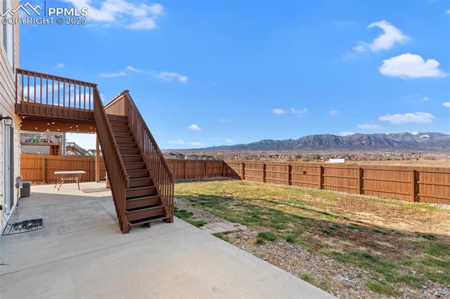 4540 Sierra Rica Road Colorado Springs, CO 80911 - Photo 11 of 42 Fenced backyard featuring a patio area, a mountain view, and stairs