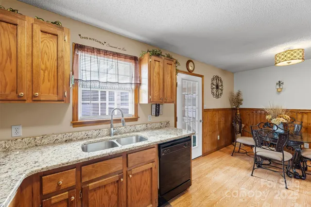 a kitchen that has a sink and chairs in it