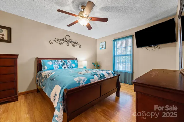 a bedroom with a bed window and a flat screen tv