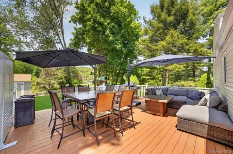 a view of patio with table and chairs under an umbrella with wooden floor