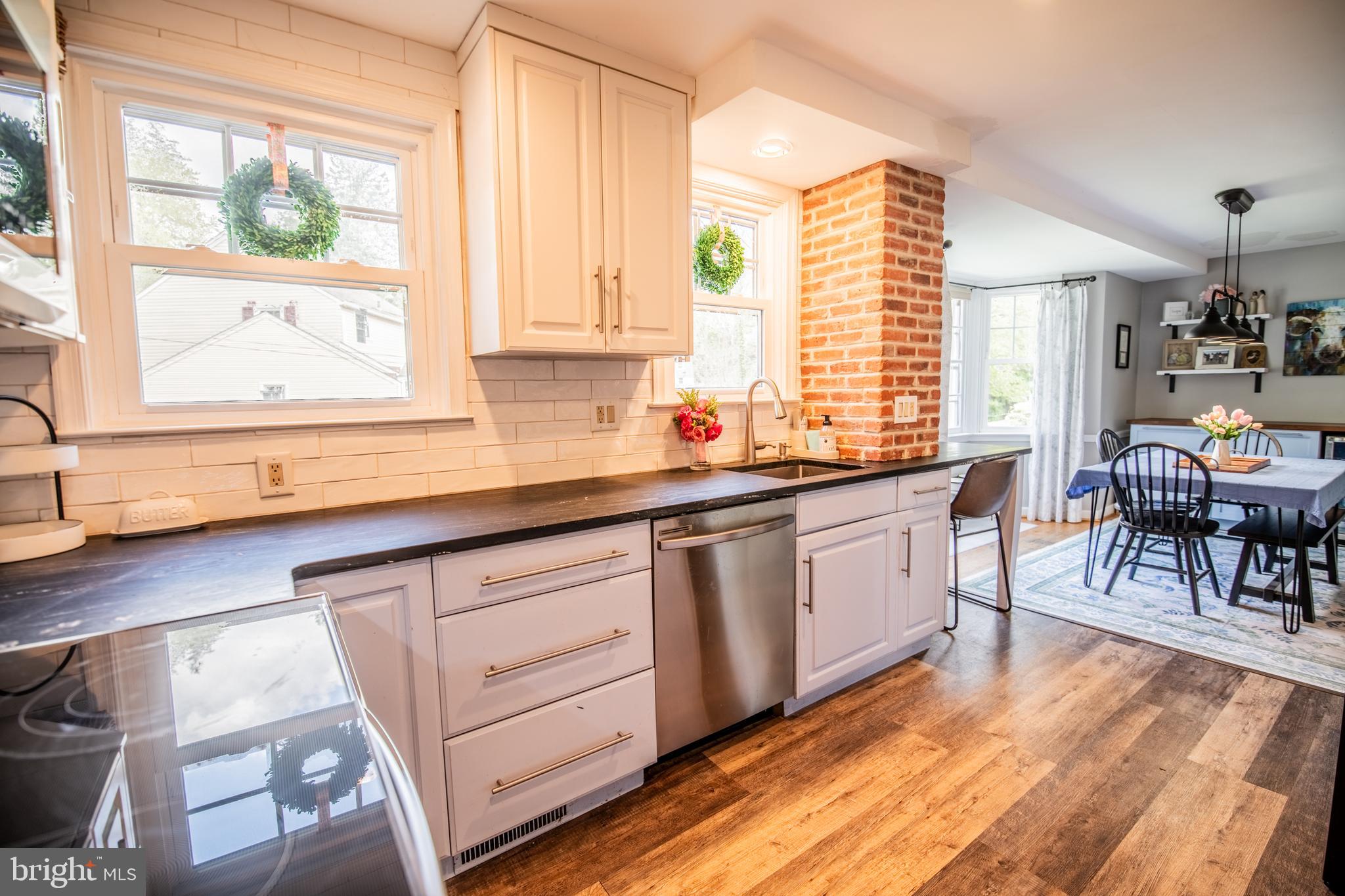 141 Cascade Road Springfield, PA 19064 - Photo 12 of 29 a kitchen with stainless steel appliances granite countertop wooden floor a sink a stove and a window