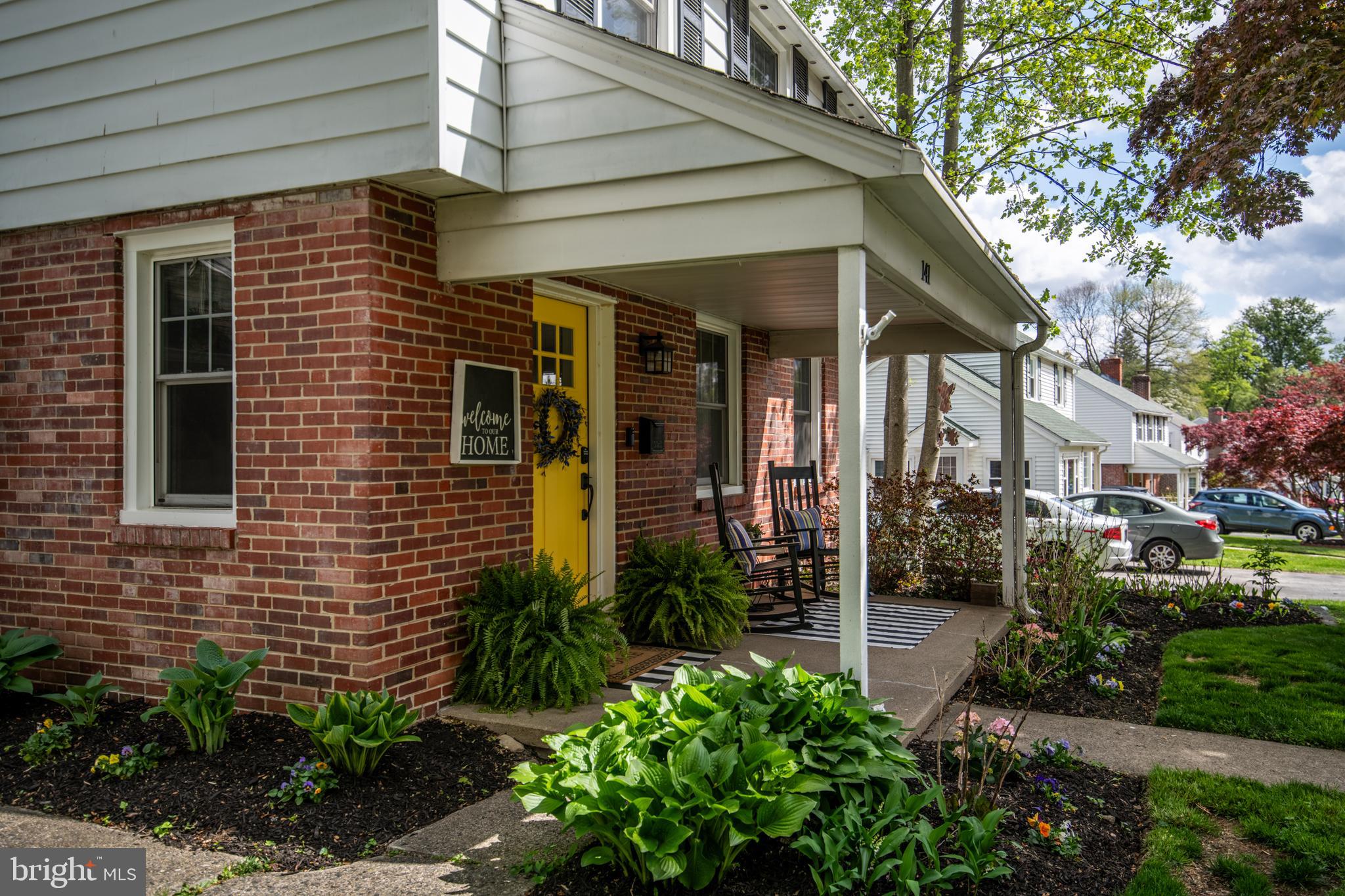 141 Cascade Road Springfield, PA 19064 - Photo 4 of 29 a view of a brick house with a yard potted plants and a table chair