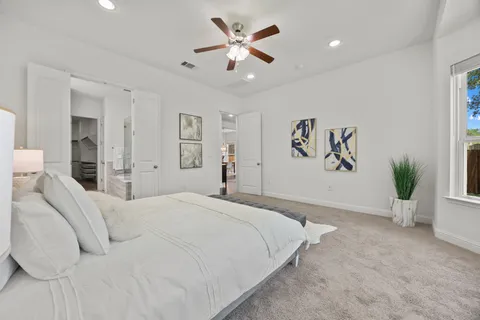 a bedroom with a large bed and a chandelier