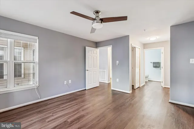 a view of a big room with wooden floor and a ceiling fan