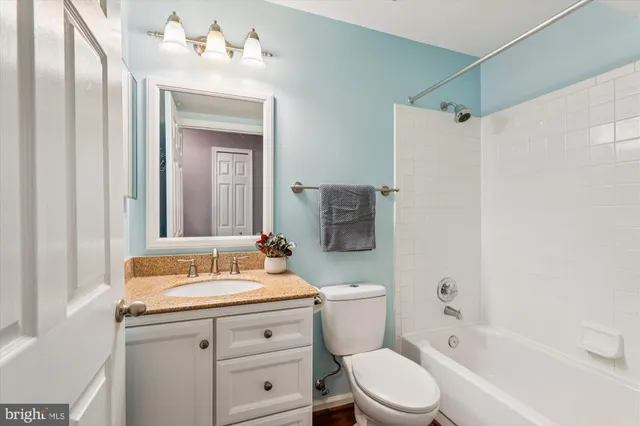 a bathroom with a sink vanity mirror and toilet