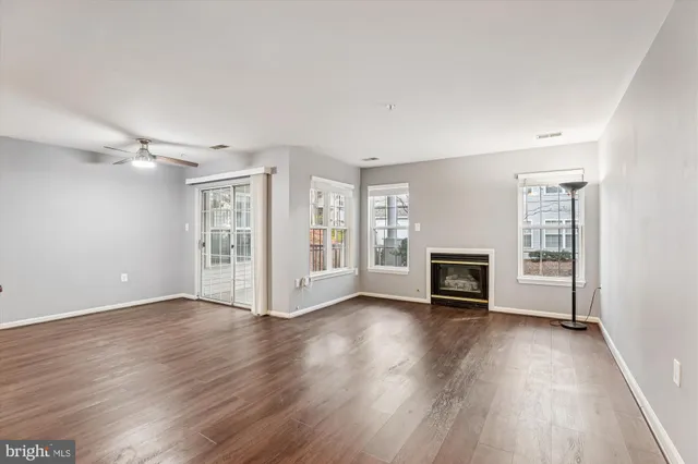 an empty room with floor to ceiling window and fireplace