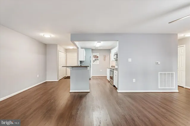 a view of a big room with wooden floor and windows