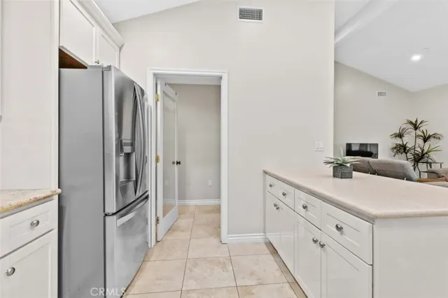 a bathroom with a double vanity sink mirror and refrigerator