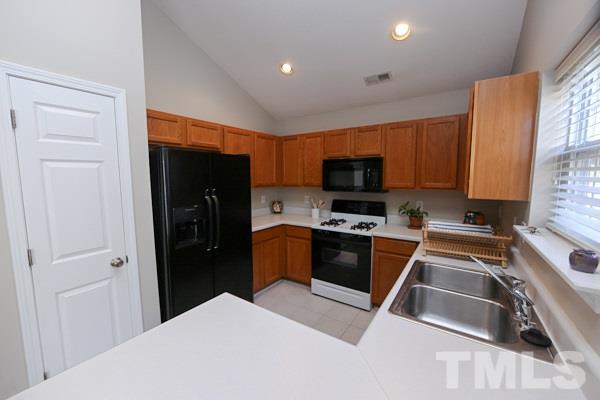 9112 Shallcross Way Raleigh, NC 27617 - Photo 6 of 16 a kitchen with granite countertop a refrigerator and a sink