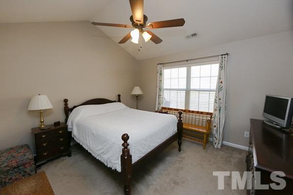 9112 Shallcross Way Raleigh, NC 27617 - Photo 8 of 16 a bed sitting in a bedroom next to a window