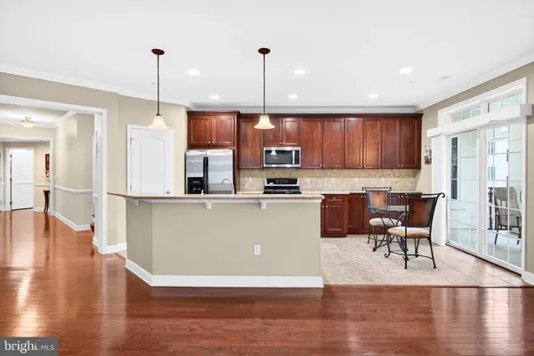 a living room with stainless steel appliances kitchen island granite countertop wooden floor a dining table and chairs