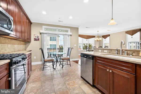 a kitchen with a stove a sink a dining table and chairs