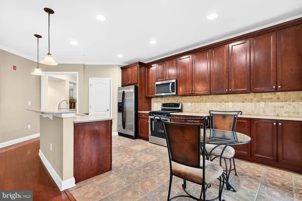 a kitchen with stainless steel appliances granite countertop wooden cabinets a stove top oven a sink and dishwasher