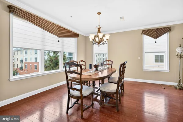 a dining room with furniture a chandelier and wooden floor