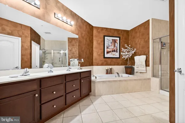 a bathroom with a tub double vanity sink and mirror