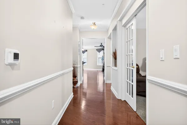 a view of a hallway with wooden floor and staircase