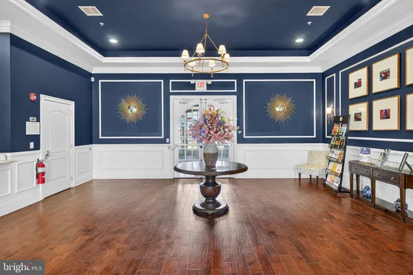 a view of a room with wooden floor and chandelier