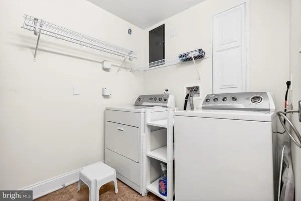 a utility room with dryer washer and empty racks