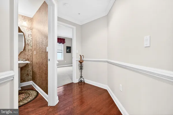 a view of a hallway with wooden floor and cabinet