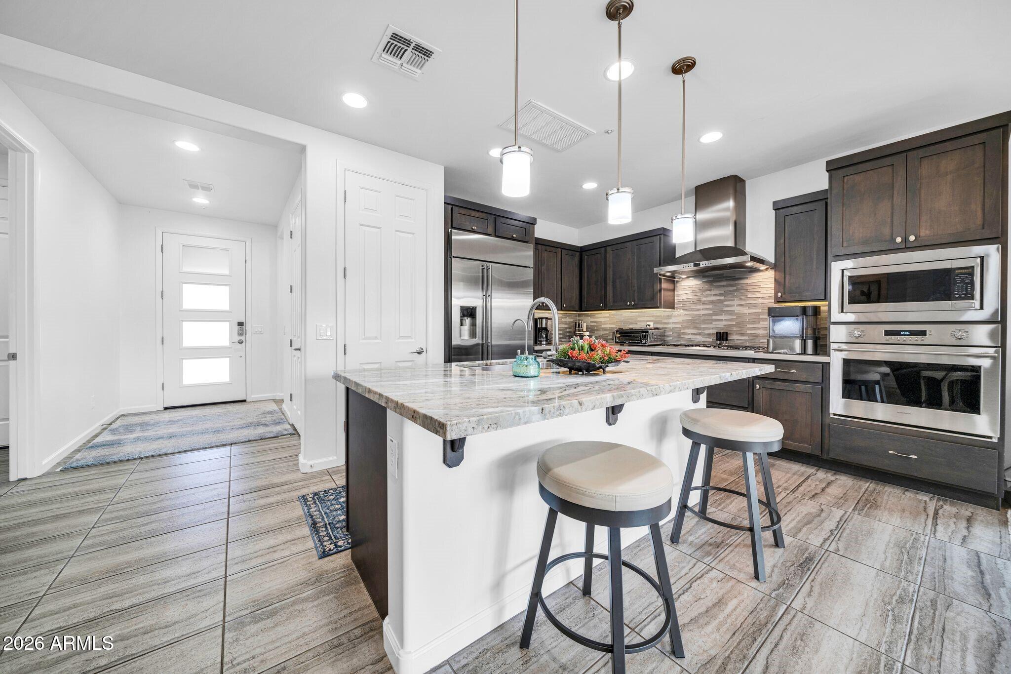 17983 East Vista Desierto Rio Verde, AZ 85263 - Photo 7 of 30 a kitchen with granite countertop a table chairs microwave and cabinets