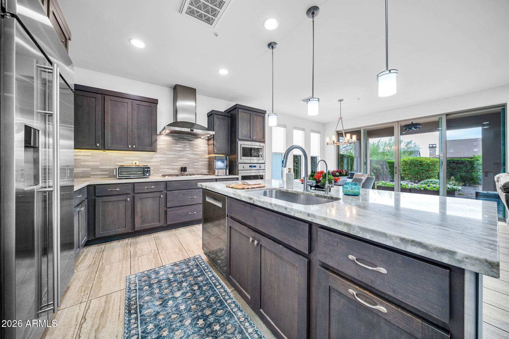 17983 East Vista Desierto Rio Verde, AZ 85263 - Photo 9 of 30 a kitchen with stainless steel appliances granite countertop a sink a stove a refrigerator and a wooden cabinets