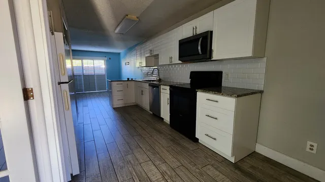 a kitchen with stainless steel appliances a stove microwave and sink