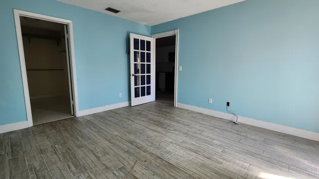 an empty room with wooden floor and closet