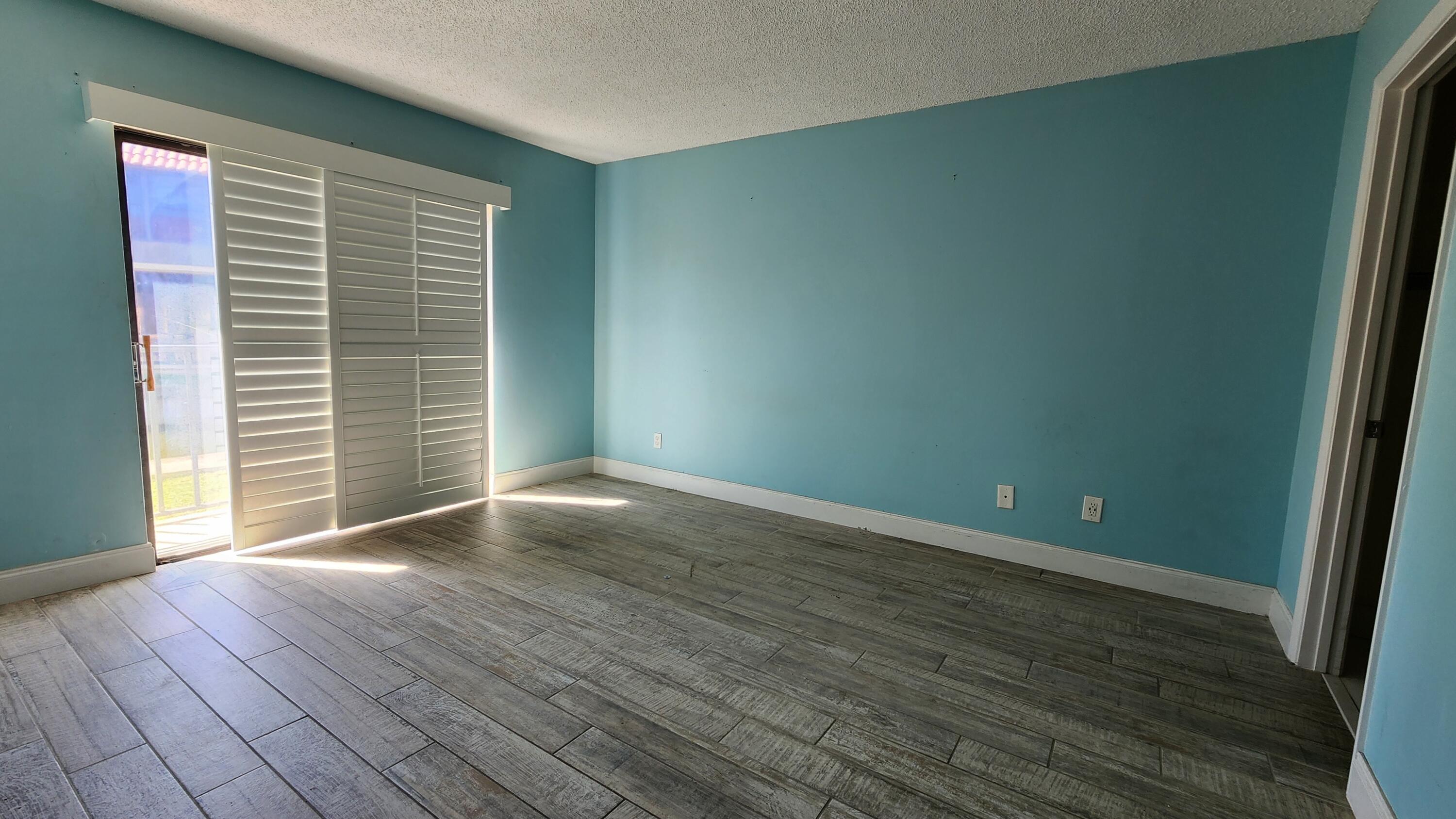 2050 Oleander Boulevard, Unit 9104 Fort Pierce, FL 34950 - Photo 13 of 27 a view of an empty room with wooden floor and a window