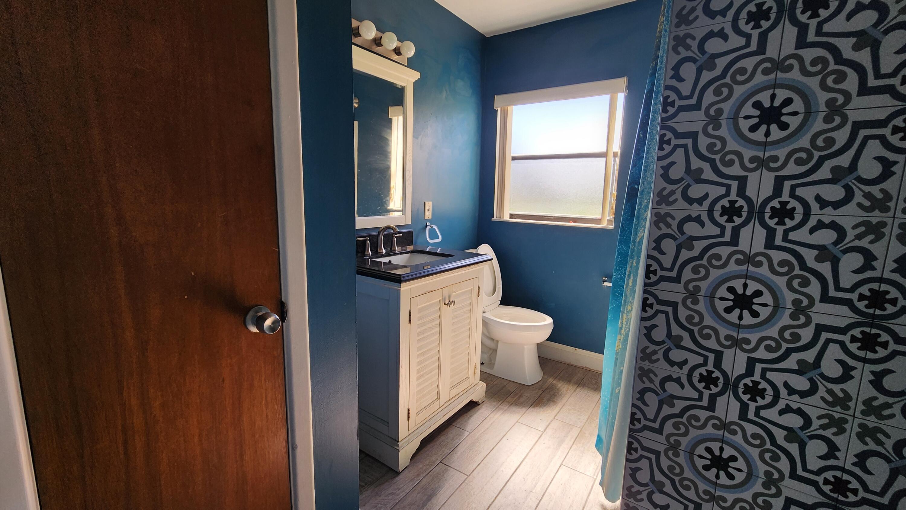 2050 Oleander Boulevard, Unit 9104 Fort Pierce, FL 34950 - Photo 17 of 27 a bathroom with a toilet and a shower curtain