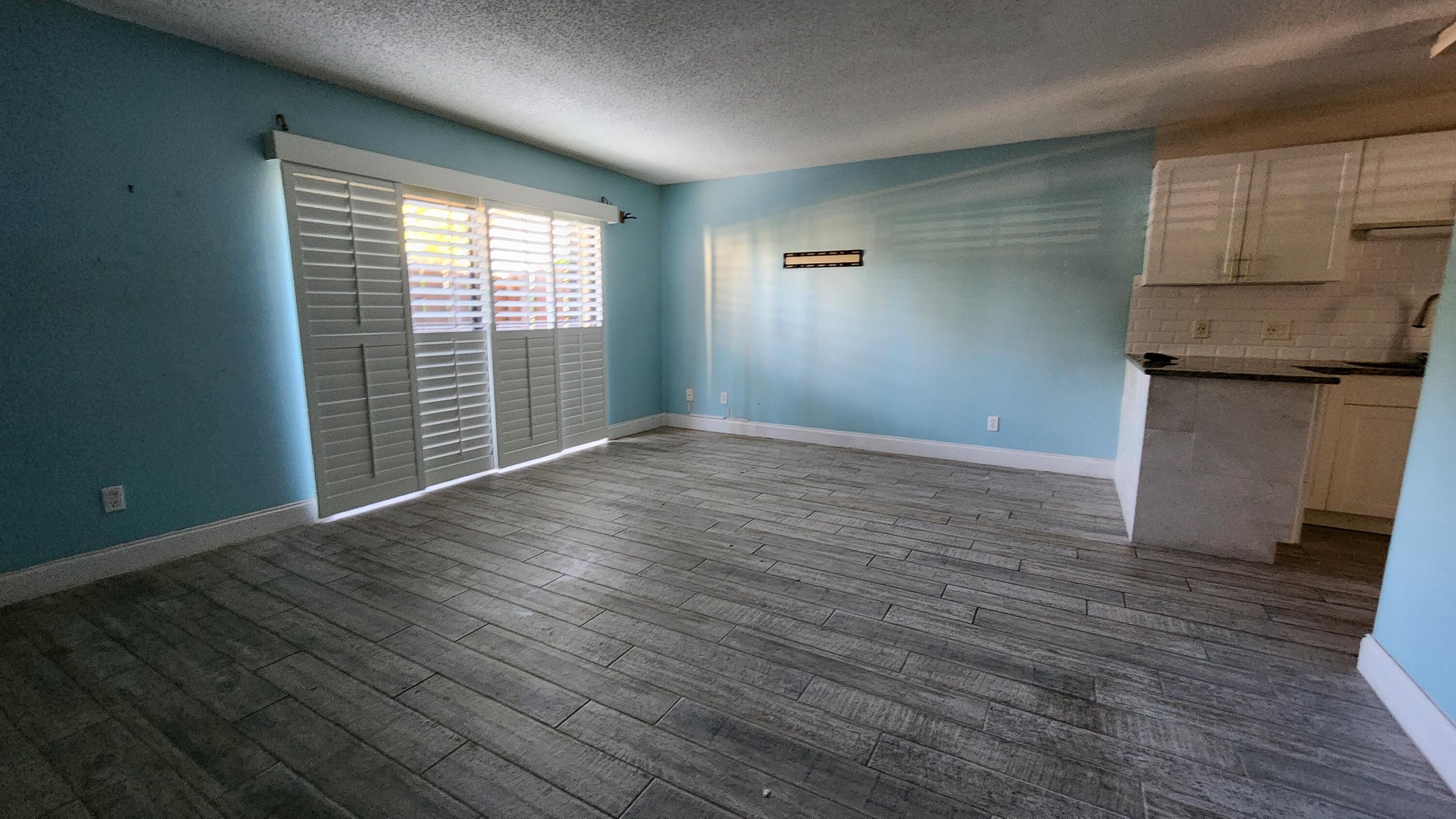 2050 Oleander Boulevard, Unit 9104 Fort Pierce, FL 34950 - Photo 6 of 27 an empty room with wooden floor and windows