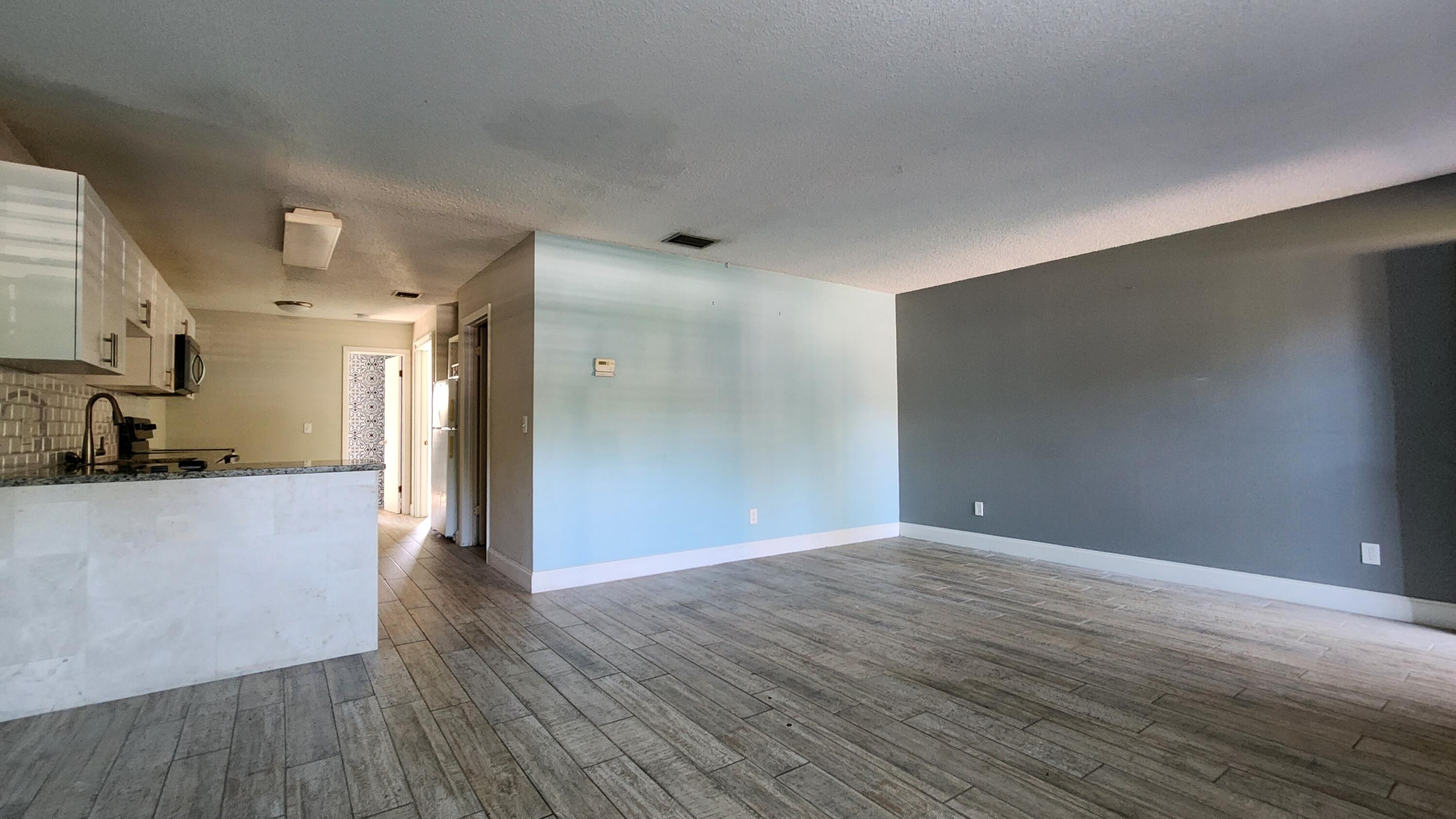 2050 Oleander Boulevard, Unit 9104 Fort Pierce, FL 34950 - Photo 7 of 27 a view of a big room with wooden floor and a kitchen
