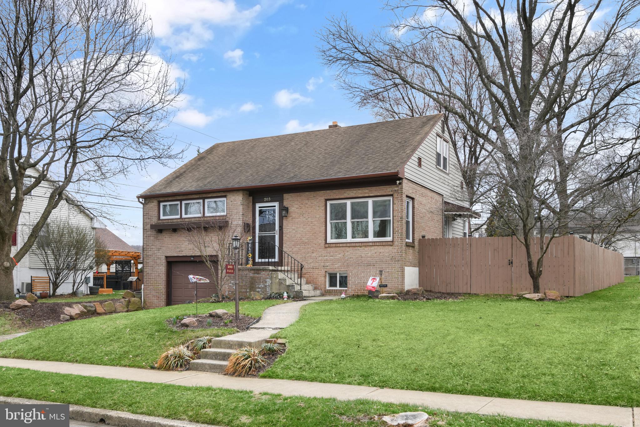 a front view of a house with a garden and yard