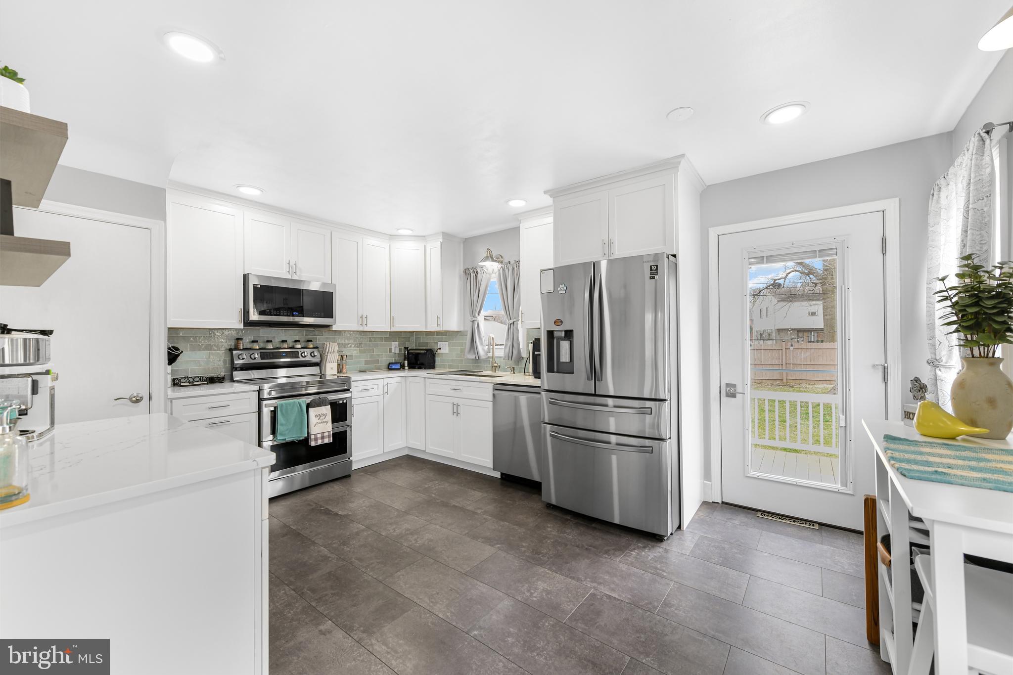 203 Eric Avenue Reading, PA 19607 - Photo 6 of 46 a kitchen with granite countertop a refrigerator and a stove top oven